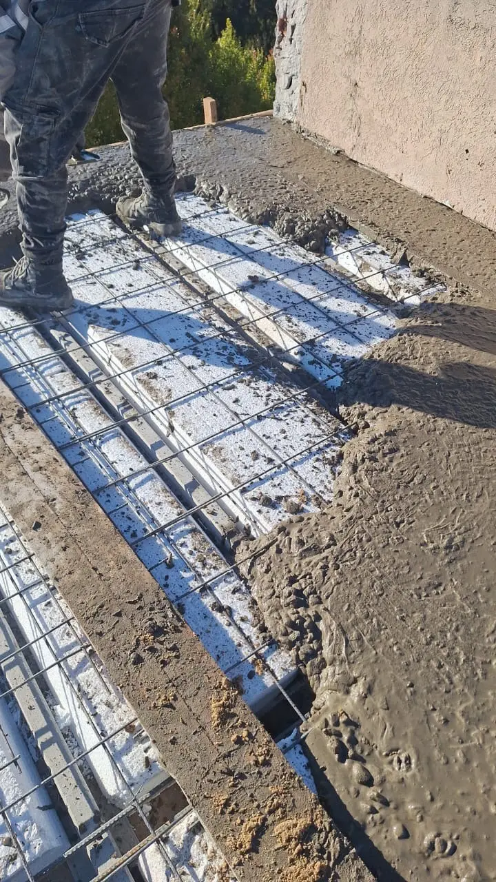 Hormigonado de losa con armadura y bloques de poliestireno en una obra de Arquiener